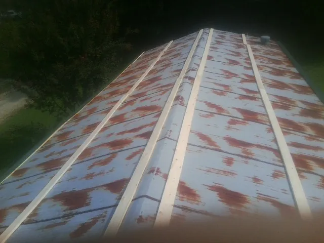 Rusted metal roof panels with new wood purlins before replacement — Storm Damage Roof Repair in Fair Play by Roofing Brothers