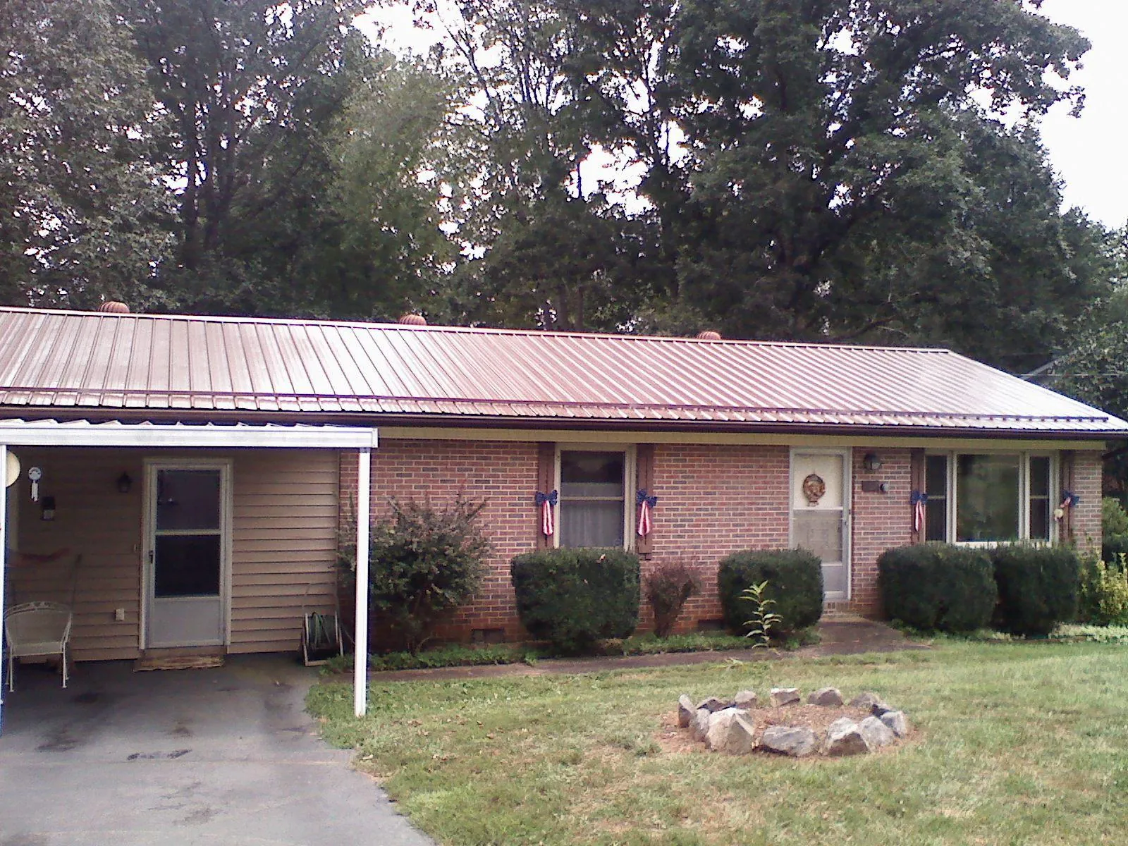 Bronze metal roof and carport on a brick ranch home — Roof Repair work by our crew in Fair Play